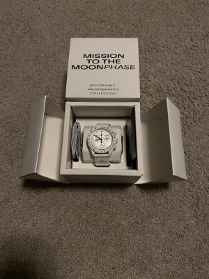 Omega x Swatch MoonSwatch Moonphase Snoopy - Säljer en Omega x Swatch MoonSwatch Mission to the Moonphase i helvitt. Klockan har biokeramisk boett, vit textilrem med Omega-logga och detaljerad urtavla med kronograf och månfaskomplication. Riktigt clean och futuristisk look.