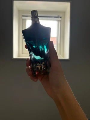 Jean Paul Gaultier Le Male parfym - Ikonisk parfymflaska från Jean Paul Gaultier formad som en manlig torso i blått och silver. Flaskan har metallisk spraytopp och en cool, modern design som verkligen sticker ut i badrumshyllan. Perfekt för dig som gillar unika och snygga parfymer.