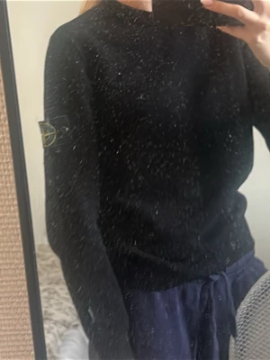 Svart tröja från Stone Island - Svart långärmad tröja från Stone Island med logotyp-patch på vänster ärm. Tröjan är i mjukt material och har ribbade muddar vid ärmslut och nederkant. Använd och köpt för 2000kr. OBS står storlek M i tröjan men den är mindre som S/xs !!