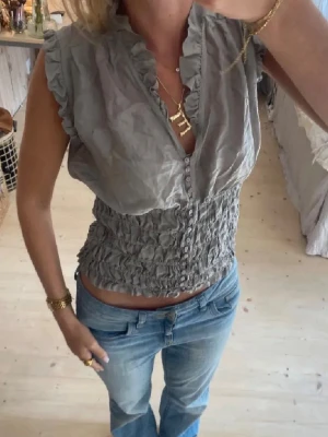 Grå volangblus från Zara  - Supersöt grå blus från Zara med volangdetaljer längs ärmhål och krage. 100% silke