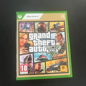 Grand Theft Auto V Xbox Series X - Grand Theft Auto V till Xbox Series X är ett actionfyllt äventyrsspel med öppen värld. Omslaget är grönt och spelet levereras i ett plastfodral. Spelet har 18-årsgräns och erbjuder både singleplayer och online multiplayer. Perfekt för dig som gillar fartfyllda spel.