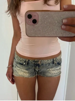Lågmidjade shorts med pärlor - Såå fina slitna lågmidjade vintage jeansshorts med pärlor! midjemått rakt över: 40. Jag är 168 och det är mina bilder, köp via köp nu direkt eller Swish, kvar tills markerad som såld 💖 