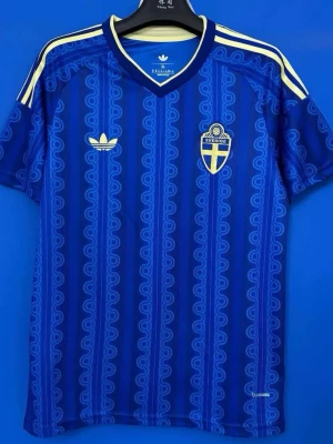 Blå Sverige fotbollströja Adidas - Säljer en blå fotbollströja från Adidas med Sveriges landslagsemblem på bröstet. Tröjan har gula detaljer, klassiska Adidas-ränder på axlarna och ett mönster i tyget. Tillverkad i ett lätt och ventilerande material, perfekt för träning eller match.