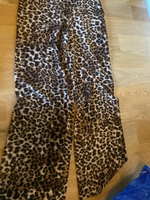 Leopardmönstrade leggings - Säljer ett par snygga leopardmönstrade leggings med breda ben. De har en cool och trendig look med bruna och svarta toner. Perfekta för dig som vill sticka ut och addera lite edge till din outfit.
