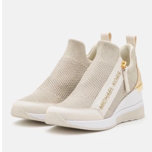 Beige sneakers från Michael Kors - Stilrena beige sneakers från Michael Kors med stickad ovandel, gulddetaljer och vit platåsula. Skorna har en slip-on design med dragflik bak och logga på sidan. Köptes från Zalando.
