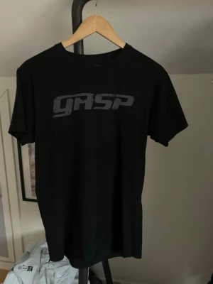 Svart GASP t-shirt i bomull - Säljer en svart t-shirt från GASP med tryckt logga på bröstet. Klassisk rund hals och korta ärmar. Tillverkad i mjuk bomull som är skön att bära. Perfekt för dig som gillar enkel och stilren design. Hör av dig vid minsta fundering eller fråga och pris kan diskuteras! 😊🙌
