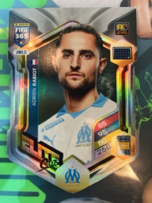 Panini FIFA 365 Adrenalyn XL kort - Säljer ett Panini FIFA 365 Adrenalyn XL samlarkort med holografisk yta. Kortet har Marseille-logga, spelarinfo och färgstarka detaljer i guld, blått och silver. Perfekt för dig som samlar på fotbollskort eller vill boosta din samling.