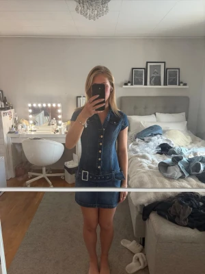 Jeans klänning  - Säljer denna snygga jeansklänningen från bershka. Den har som ett skräp men de kan man även ta bort. Aldrig använd. 