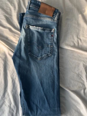  Replay jeans - Säljer ett par klassiska blå jeans från Replay i modellen grover (slim fit). Storlek W31 och L34. De är i mycket bra skick och är lite tighta på mig och har lite slitningar som ger ut grisch stilen mer  och ser snyggare ut. Som är 188cm och väger 78kg men längden passar bra.