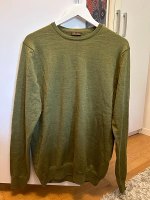 Olivgrön stickad tröja Stenströms - Snygg olivgrön stickad tröja från Stenströms med rund halsringning och långa ärmar. Tröjan har ribbade muddar vid ärmslut och nederkant. Tillverkad i tunt, mjukt material som passar perfekt till lager på lager.