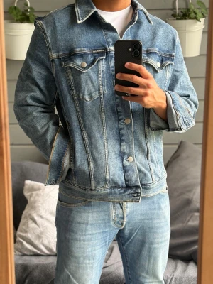 Calvin Klein jeansjacka - Säljer denna snygga blåa jeansjacka från Calvin Klein i storlek M, sitter mer som S. Sitter härligt nu till sommarn. Passar dig mellan 170-180cm. Jackan har inga defekter alls! Bara att kontakta vid funderingar!🌟