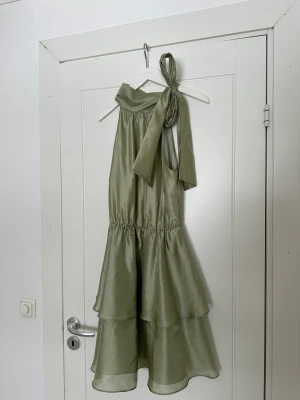 Klänning från Gina Tricot - Superfin klänning från Ginatricot! Använd 1 gång och strl 36. I skimrigt material samt knytning vid halsen. Slutsåld! 