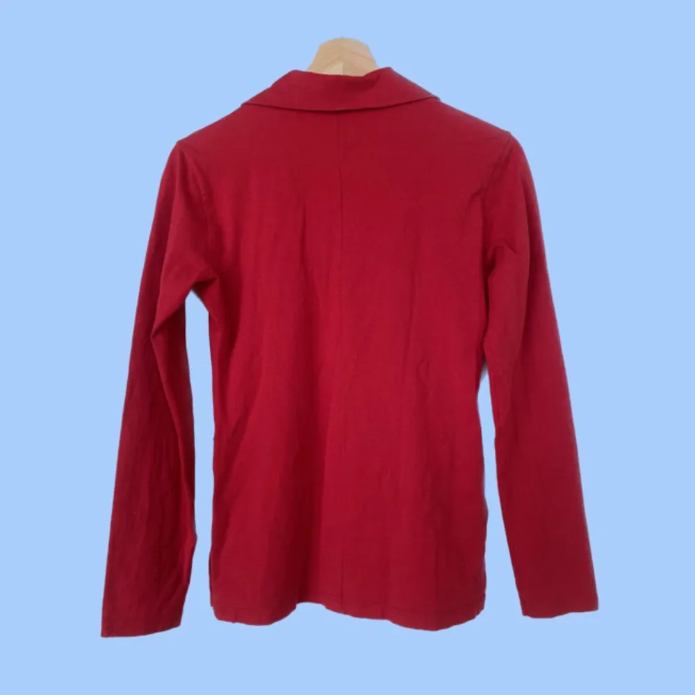 Röd långärmad tröja med dragkedja och slitsar på sidorna (ca 1 dom långa). Mycket stretch i tyget. Köpt se secondhand. Hör gärna av dig med frågor:). Toppar.