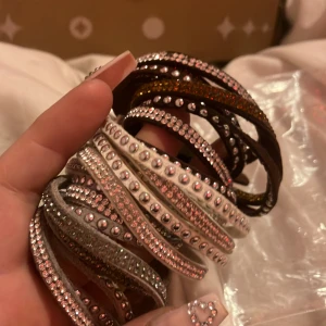 Tyg armband med stenar typ  - Tre stycken tyg armband med glitter stenar typ. I färgerna brun,vit o grå:) 