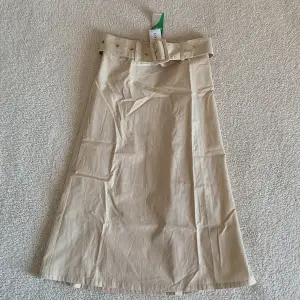 En superfin beige kjol från Ginatricot med skärp!! Så snygg till våren 🌻 Den är helt ny och har aldrig kommit till användning så därför får den gärna hamna hos någon som kan ge den lite kärlek nu. 🌻 Material: 100% bomull.