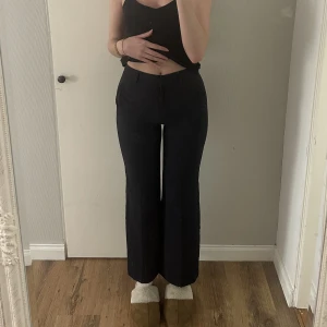 Kostymbyxor  - Marinblåa kostymbyxor från STOCKHOLM LM.  Använd endast ett fåtal gånger, som nya.  Strl 34