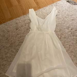En fin vit klänning som ha en roset i ryggen 