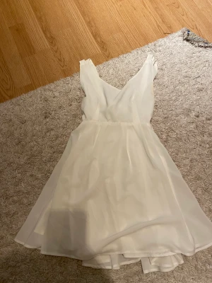 Klänning  - En fin vit klänning som ha en roset i ryggen 