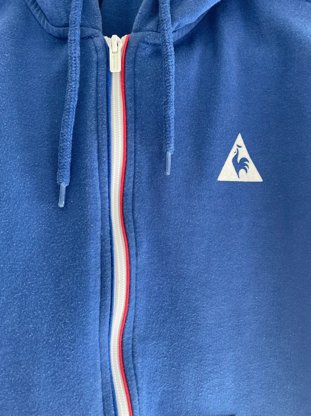 Storlek S/M blå tröja med luva franska flaggan vid zippen syns på bilden de en linje som e röd o en blå ska reppa france ☺️. Hoodies.