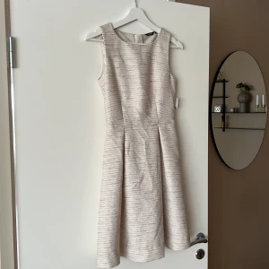 Klänning - Oanvänd klänning med prislappen kvar. Det är guldiga inslag i klänningen som inte syns så bra på bild. Nypris 499:-