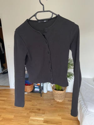 Långärmad med knappar - Supersöt tröja som aldrig är använd. Småribbad. Tack vare knapparna funkar den även utmärkt som en kofta.