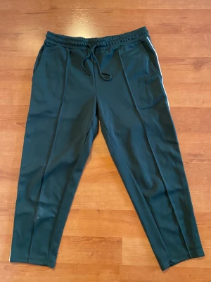 Byxor  - Lite kortare byxor i fusion mellan sweatpant & kostymbyxa. S i herrmodell sitter bra på M kvinna. Endast använda 3 ggr. Jättefin jadegrön färg