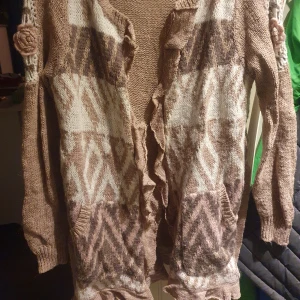 Kofta - Kofta från cream. Använd 2 gr o sen tvättad. Snörning i midjan. Mönster fram och ett fint mönster på armen. Ryggen slätstickad. Passar även L. 