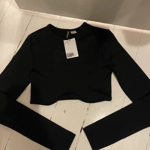 Långärmad topp - Långärmad croppad topp med detalj vid bröstet. Aldrig använd och prislapp kvar, från Hm  