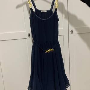 Mörkblå klänning från Ida Sjöstedt med gulddetaljer. Finns inte längre att köpa. 