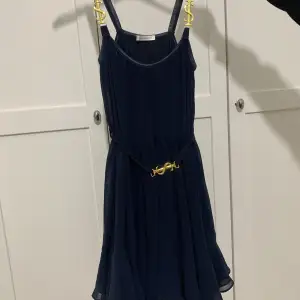Mörkblå klänning från Ida Sjöstedt med gulddetaljer. Finns inte längre att köpa. 