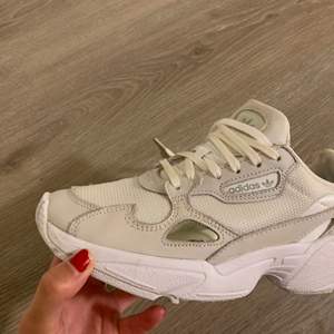 Falcon Sneakers från Adidas  Färg: beige/vita   Storlek: 38 alt. se bild Skick: använda ett fåtal ggr, finns inget att anmärka på  