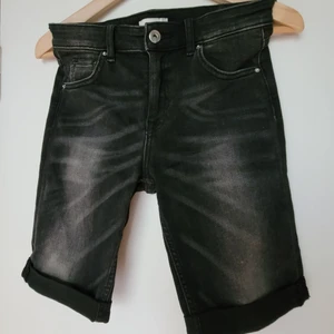 Shorts stl.34 - Säljer dessa trendiga, svarta shorts med ljusare slitningar. Stretchig bomull/elastan.Använda, välvårdade, inga fel Frakten tillkommer.