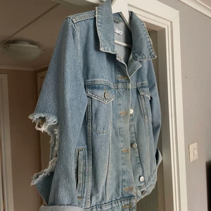 Jeansjacka - Säljer nu min jeansjacka från Nakd eftersom jag inte använder den (använd max 3 gånger). En snygg jeansjacka i ljusblå färg med slitage på armbågarna. Storlek 34 och lite oversized. Jag är 161cm lång och den sitter bra på mig.  Säljer den för 180kr+frakt