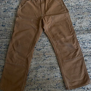 Carhartt - DOUBLE KNEE PANT - Hamilton Brown  - Carhartt byxor köpta för 1245kr i storlek 34x30. fint skick nästan aldrig använda! Frakt lägga till i pris vid köp!  Eller träffas i Lund/Malmö 