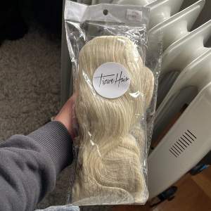 En helt oanvänd 70 cm lång kall blond syntetisk hårsvans som heter Kelly, från Tizwe🤍