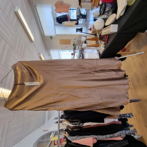 Kjol - Kjol i guldskimrande tyg. Lång modell Faller snyggt. Aldrig använd 