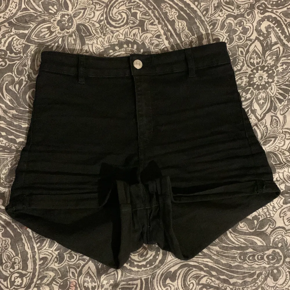 Ett par svart högmidjade jeans shorts, dem är lite urtvättade så dem är lite mjukare i materialet än vad vanligtvis jeans material är.. Shorts.