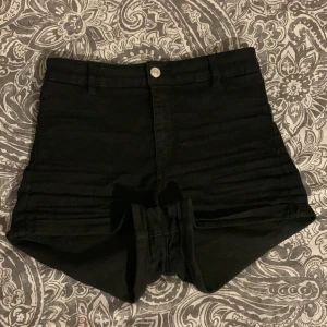 Svarta basic jeans shorts - Ett par svart högmidjade jeans shorts, dem är lite urtvättade så dem är lite mjukare i materialet än vad vanligtvis jeans material är.