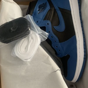 Jordan 1 - Ett par jordan 1 marina blue i storlek 40 EU, använda 2 gånger och sedan bevarats i lådan. Blåa samt vita skosnören är inkluderade. Säljs då dem inte är min stil. Nike bekräftelse tillkommer.