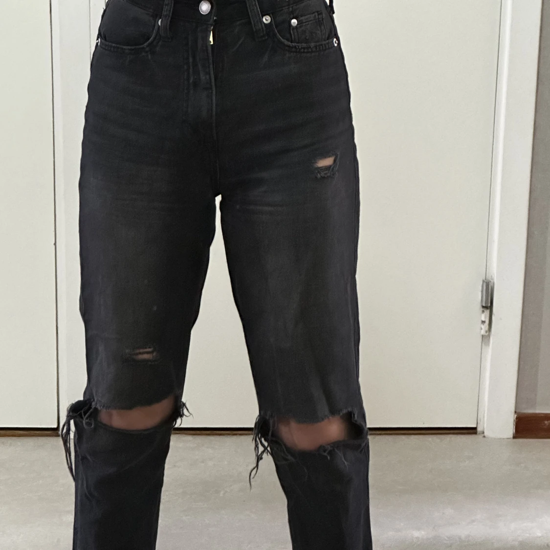 Svarta byxor med hål i