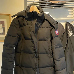 Canada Goose Wyndham (Size S)  - Hej tänkte sälja min jacka då jag är intresserad av något nytt eventuellt byte + pengar mot en Canada Goose väst i samma kvalite.  Kvaliten är väldigt god, jag har tagit hand om den väl och aldrig rökt med den.   Kontakta mig för frågor eller fler bilder