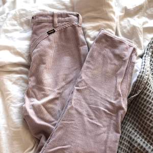 High waist jeans i medellängd, pastellfärgade lila/rosa. Nästan perfekt skick med någon enstaka fläck och opolerade metalldetaljer. Storlek W27 L32. Väldigt lena och mycket bra tygkvalitet. Använda. Modell: 80S SLIM