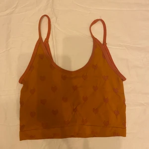 Crop top - En fin top från Urban outfitters. Orange med rosa hjärtan i stretchigt material 