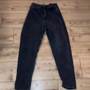 Svarta Hm mom jeans  - Från Hm. Ett par mom jeans. Svart/gråa byxor. Storlek 38 men passar på 36/34 också. Lite kortare än vanliga  hm jeans. Lite för långa för mig som är 1,57 cm lång. Halvår gamla ungefär. Inte så använda för det har inte varit min stil. Men bra skick! Frakten kan diskuteras ( frakten som står gills inte )!!