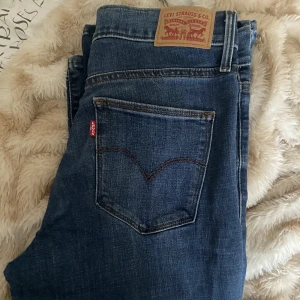 Levis slimming boot - Ett par levis slimming boot i en mörkare jeansfärg med stretchigt material, och bootcut! Storlek 29 som motsvarar en M Jeansen är använda fåtal gånger då det inte var min stil och därför mycket sparsamt använda och i fint skick. 
