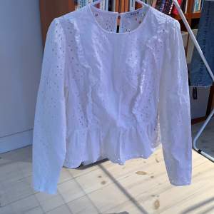  En vit blus med volang som har används ett par fåtal gånger