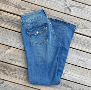 Lågmidjade bootcut jeans - Blåa lågmidjadade bootcut jeans från hm, knappt använda💙💙 Midjemåttet är typ 79cm. Innerbenslängden är typ 76 cm💖(bilderna är lånade)