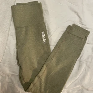 Träningstights - Träningstights från gymshark i adapt, storlek XS, säljes då de är försmå, har haft ett hål i benet men har sytt förut och har funkat så de är väl defekten