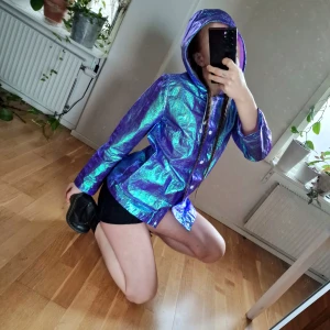 Metallic regnjacka - VÅRRENSNING! Metallic regnjacka som skiftar i lila/blått. Bästa jackan för festivalen/under sommaren för att göra en regnig dag lite bättre. Bli någons regnbåge! 🌈