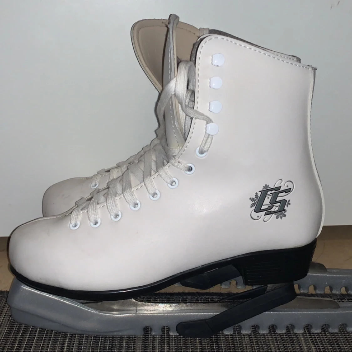 Cs skridskor med silver färgad skridskors skal 